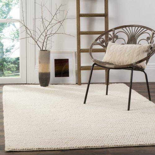 Cozy minimalist room with a white rug, a chair, ladder, and decorative vases.